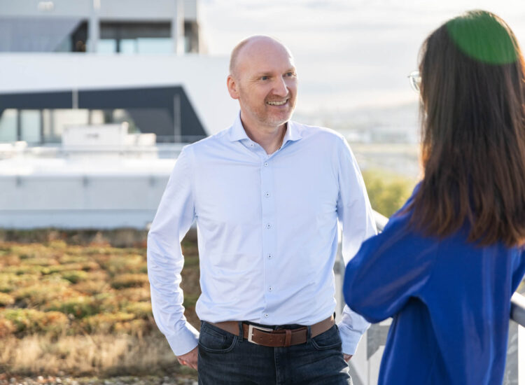 An employee talking to a colleague on the roof terrace of the STAR building.