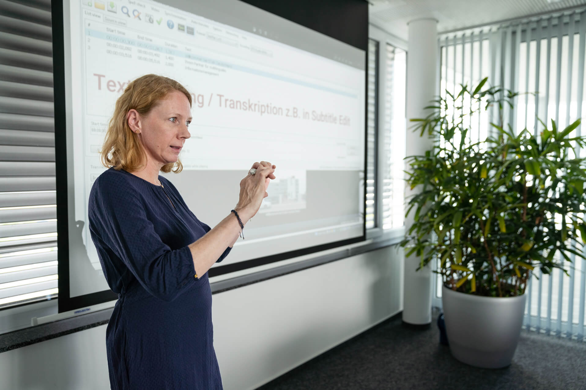 STAR Mitarbeiterin hält einen Vortrag über Multimedia-Lokalisierung vor einem Whiteboard.