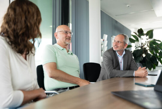 STAR Mitarbeiter mit Geschäftsführer in einem Meeting zum Thema Qualität und Sicherheit am Besprechungstisch.