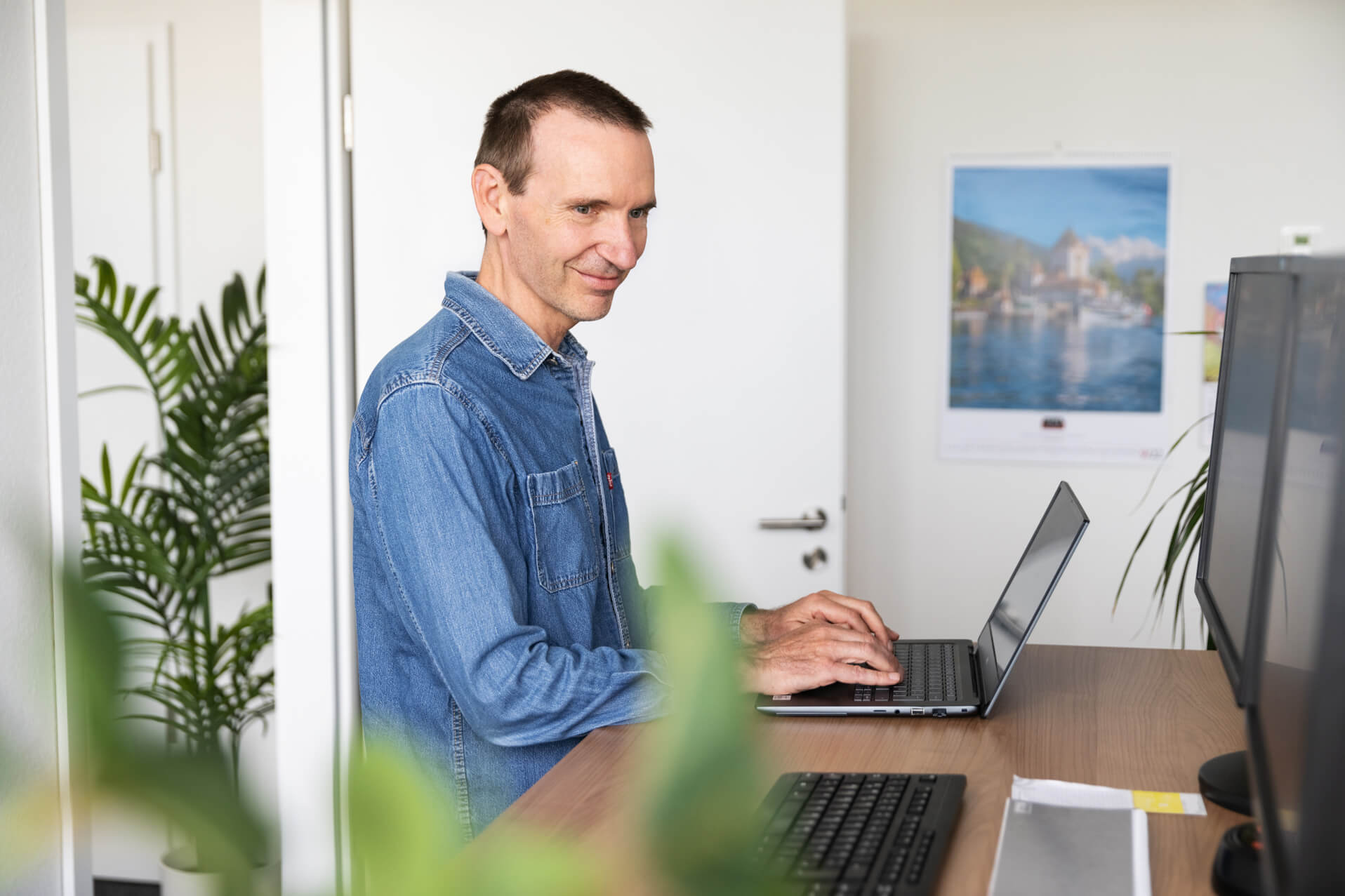 Technischer Redakteur bei der Arbeit an Stehschreibtisch.