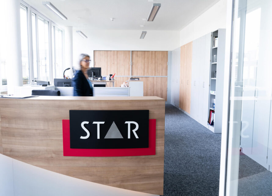 STAR Empfang mit großem STAR Logo und Mitarbeiterin in Bewegung.