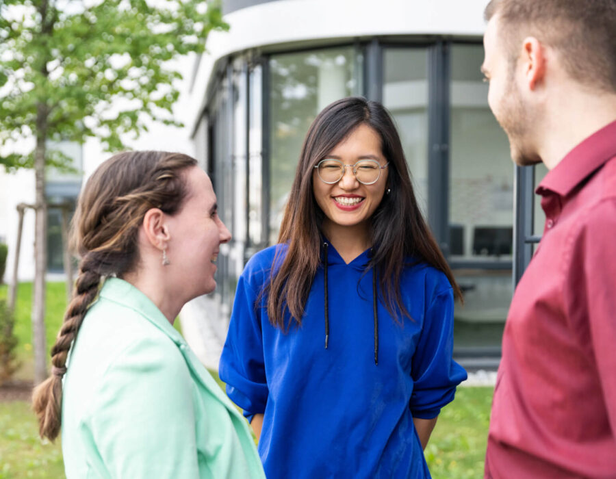 Three STAR team members in a conversation about terminology management in front of the STAR Germany building.