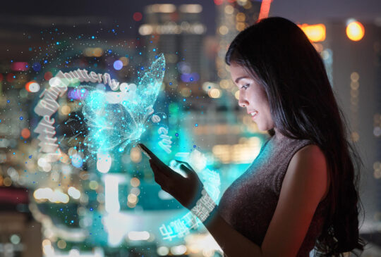 Person arbeitet mit Transit NXT auf ein Smartphone über dem ein funkelnder Schmetterling schwebt.