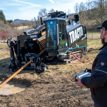 TRACTO drilling rig in operation for trenchless pipe installation, controlled via remote control on a construction site as part of a successful industrial project.