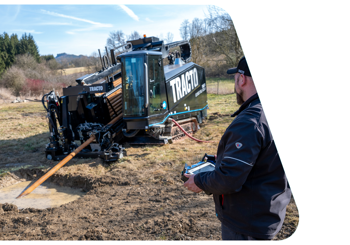 Bohranlage von TRACTO im Einsatz für grabenlosen Leitungsbau, gesteuert per Fernbedienung auf einer Baustelle im Rahmen eines erfolgreichen Industrieprojekts.